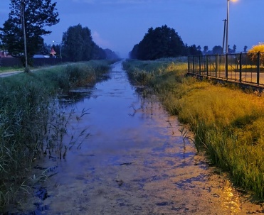 Wieczorny krajobraz Karwi, kanał przy plaży, nadmorska ścieżka i spokojny klimat wakacji.