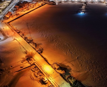 nocne zdjęcie z góry, oświetlony port / plaża zimą