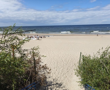Spokojna plaża z widokiem na fale Bałtyku w Pobierowie.