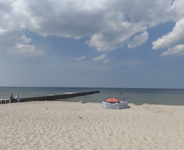 Piaszczysta plaża z leżakami i parawanami.Pogorzelica