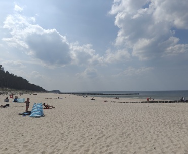 Pogorzelica - Piaszczysta plaża z leżakami i parawanami.