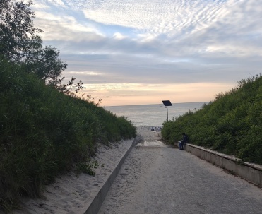 Zachód słońca oglądany z zejścia na plażę.
